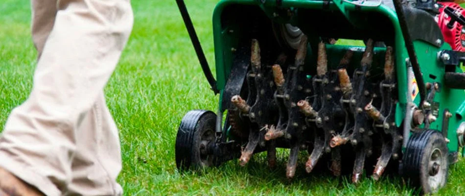 Person aerating a lawn in Charlotte, NC.