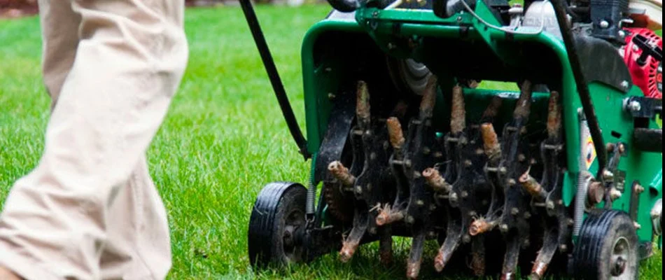 Green aerator machine in Charlotte, NC, pulling up soil cores.