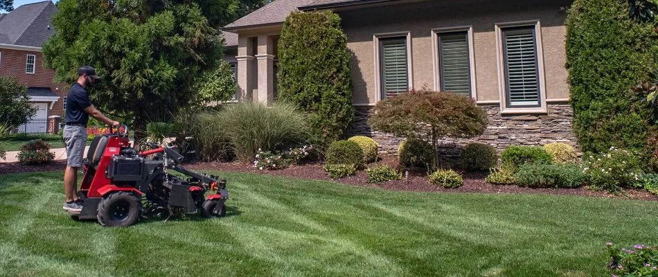 Employee aerating and seeding lawn in Harrisburg, NC.