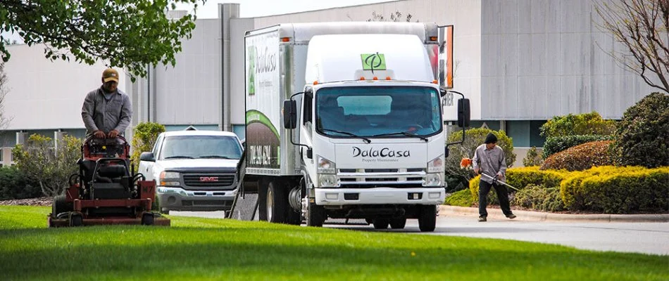 Company truck and workers maintaining a commercial lawn in Charlotte, NC.