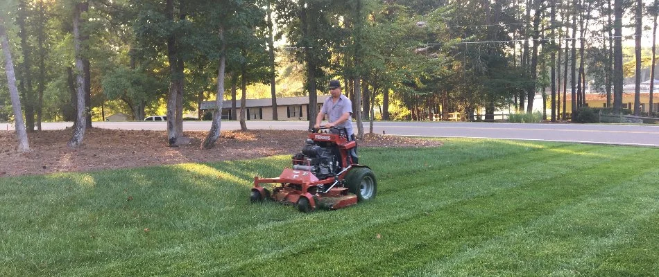 Worker in Concord, NC, mowing grass.