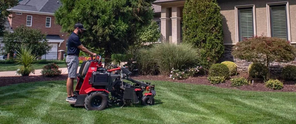 Crew on an aerator and grass seed spreader machine on a lawn in Charlotte, NC.