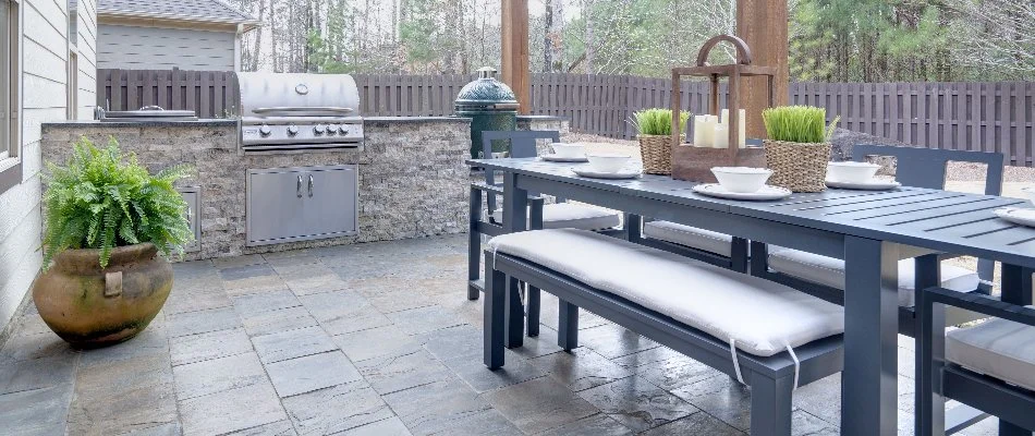 An outdoor kitchen in Lake Norman, NC, with seating and a grill.