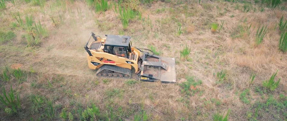 Skid steer in a field in Charlotte, NC, for bush hogging.