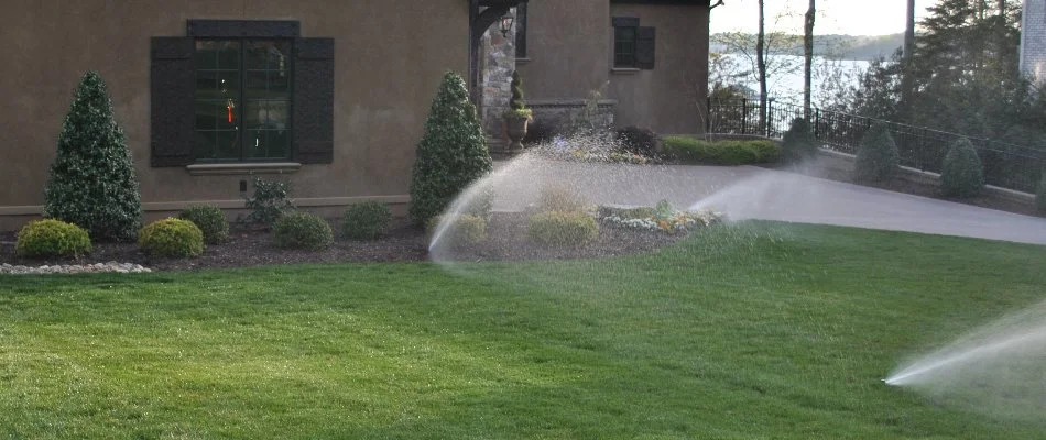Sprinkler heads in a yard in Mint Hill, NC, watering grass.