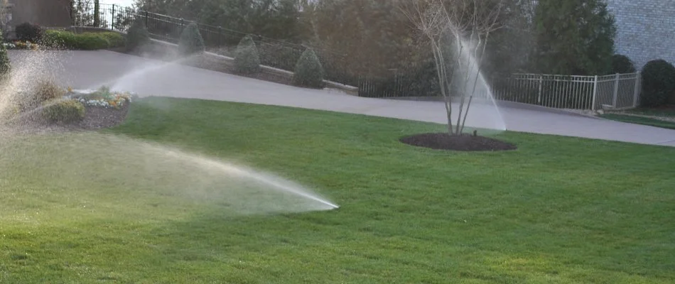 Sprinkler irrigation system spraying water on a lawn in Huntersville, NC.