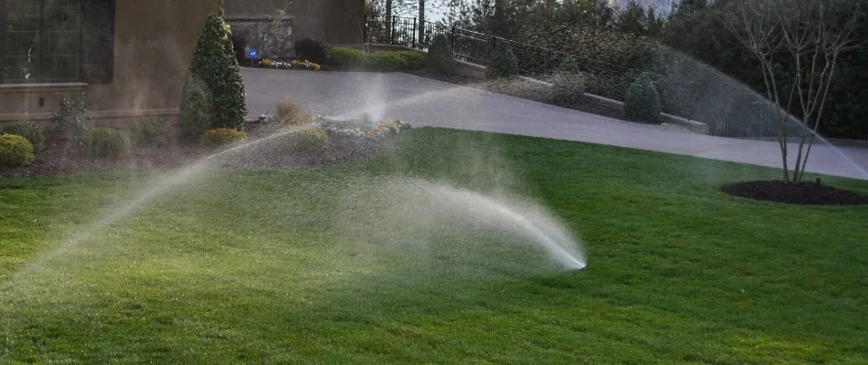 Sprinkler irrigation system spraying water on grass in Waxhaw, NC.